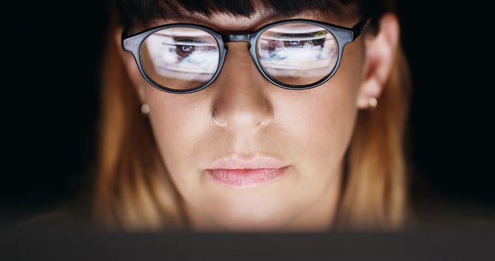 暗い部屋でパソコンを使用してる女性