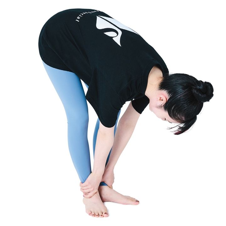 つま先をVの字に開いて立つ。縦長のダイヤモンドを作るイメージで膝を軽く曲げる。前屈して両手で足首を掴み、10～15秒キープ。