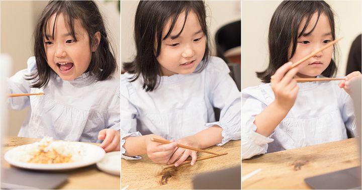 お箸を上手に使おうと練習している女の子