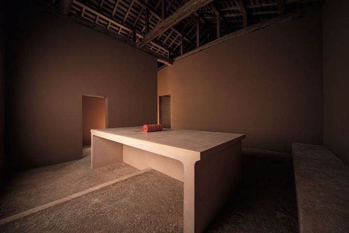 リビングでもある通称「土の部屋」。壁は同じ赤土を使っていても、光の入り方によって色彩が変わり、さまざまな表情を見せる。Photo_ Kim Ilda