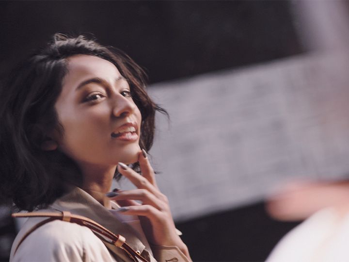 ベージュのアウターにルイヴィトンのショルダーバッグを肩にかけた木佐貫まやさん