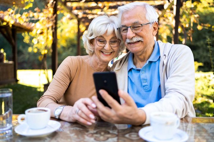 携帯電話を使用するシニアカップル