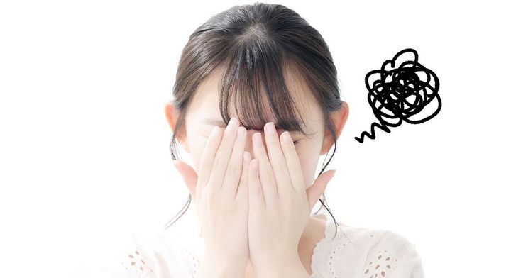 両手で顔を覆う女性