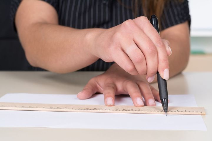 ペンと定規で線を引く人