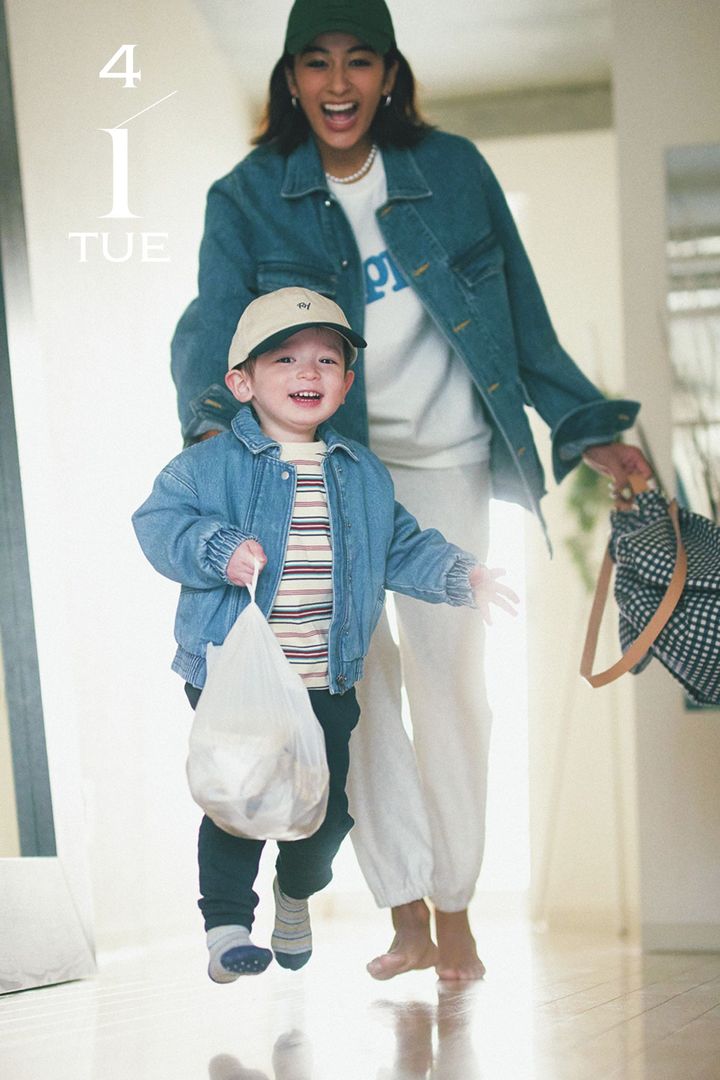 ロゴTシャツとスウェットパンツにGジャンを羽織ってキャップを被り子どもを追いかける木佐貫まやさん