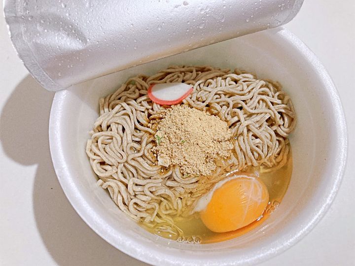 湯切りした麺に卵や粉末スープを入れる