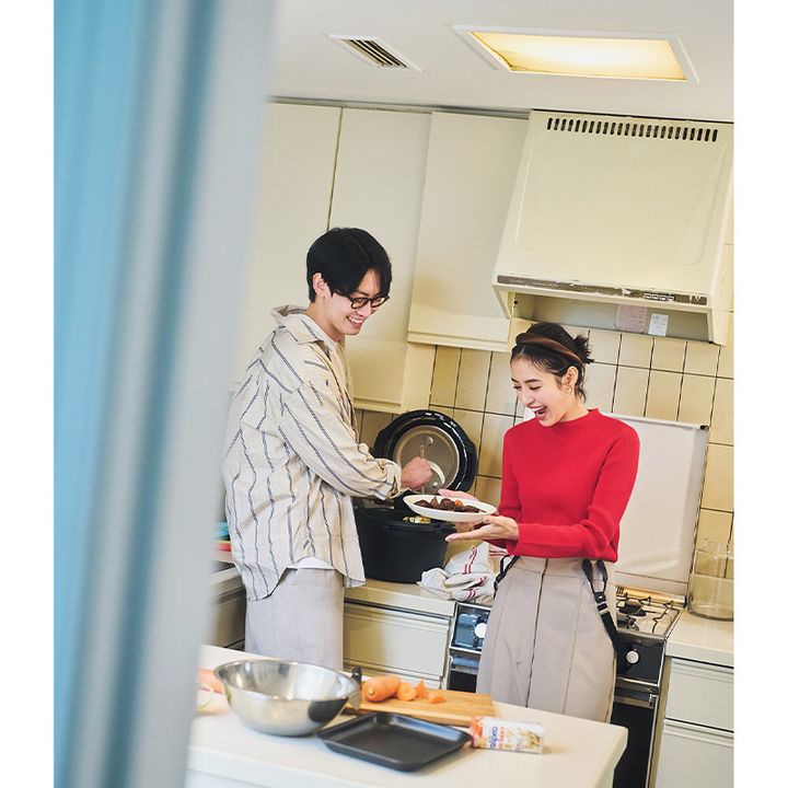 赤ニットにベージュのサスペンダーパンツを合わせた着こなし