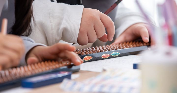 そろばんをはじく子どもの手元