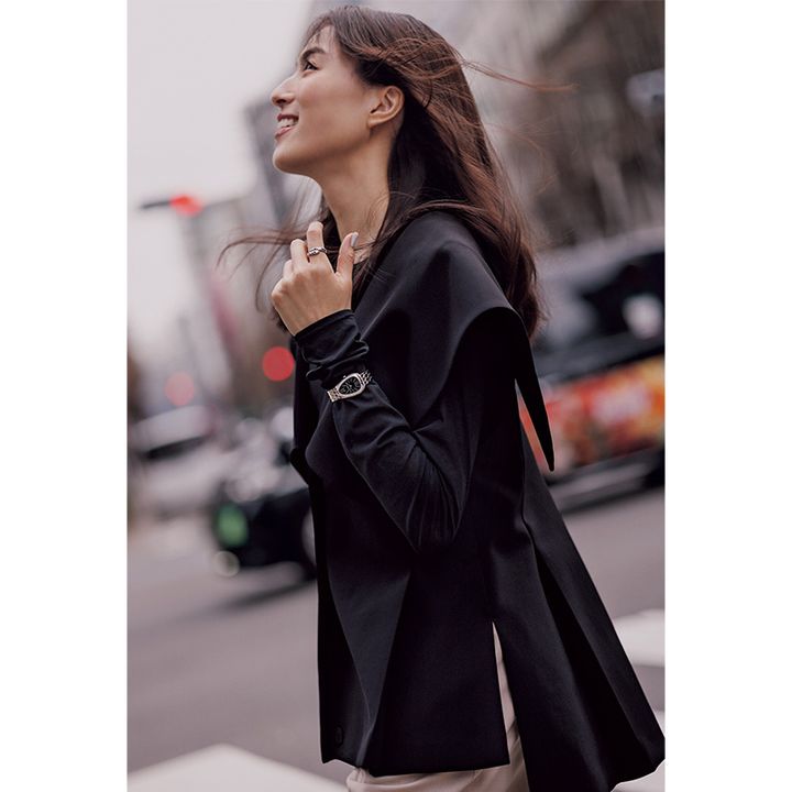 黒いトップスとジレを着た手元にブルガリの腕時計をつけた笹川友里さん