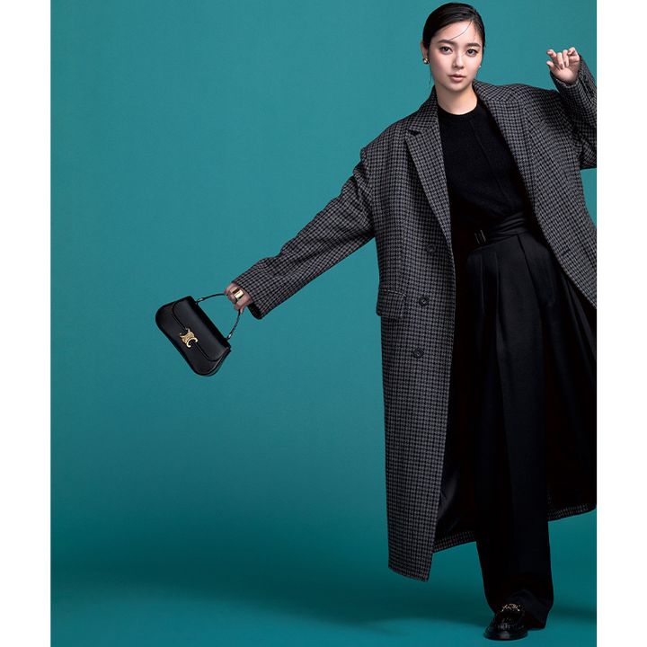 黒ニットとパンツにチェックのコートを羽織ってセリーヌのトリオンフがついたミニバッグを持った新川優愛さん