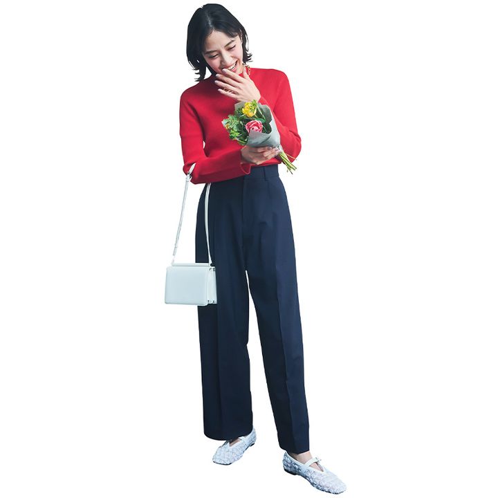 赤ニットとネイビーワイドパンツに白系のバッグとシューズを合わせたコーデ
