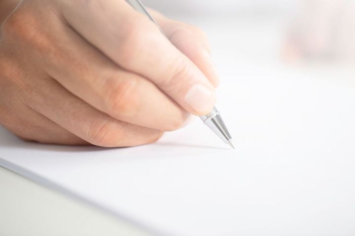 何かを書いている人の手元