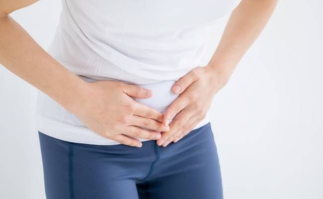 下腹部を両手で抑えるイメージ