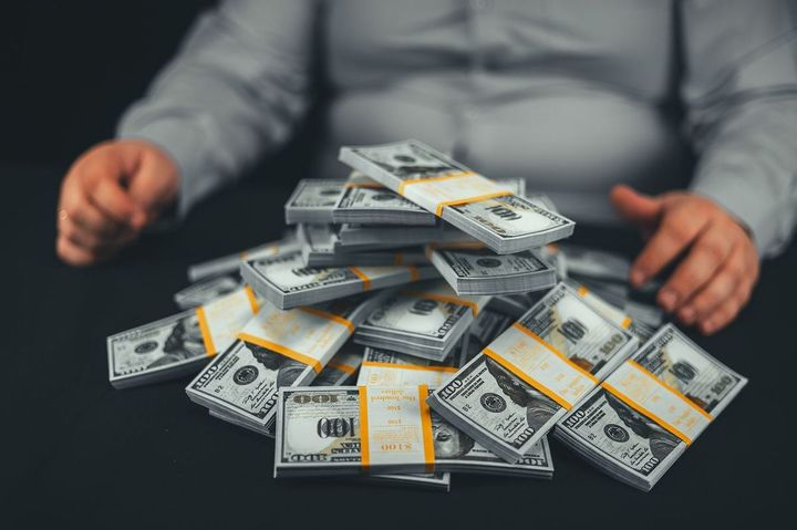 男性の前に置かれた大量の札束