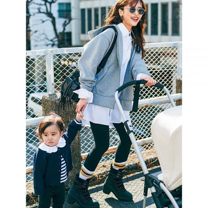 シャツ×レギンスにグレーパーカーを羽織り子どもモデルと手を繋いでいる近藤千尋さん