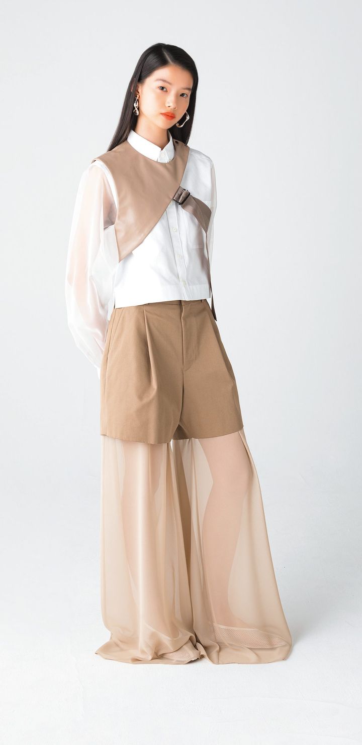 アシンメトリーなデザインに加え、合皮のクールな質感も特徴的なトップス。ワークウェアの要素を感じさせるベルトは、アジャスターでフィット感を調節できるので、シャツにはもちろん、アウターの上に重ねても。見慣れた服も一気にブラッシュアップしてくれる。季節を問わず使えるのもうれしい。
