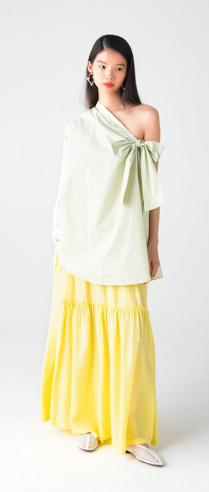 テーラリング技術を生かした服作りに定評のあるイタリア発ブランド『テラ』。リボンのあしらいが目を引くワンショルダーブラウスは、自然なドレープが生まれるゆったりとしたサイジング。ハリのあるコットンポプリン生地により、美しいシルエットをキープできる。ミントグリーンの繊細な色合いも、洗練されたムードをもたらす。