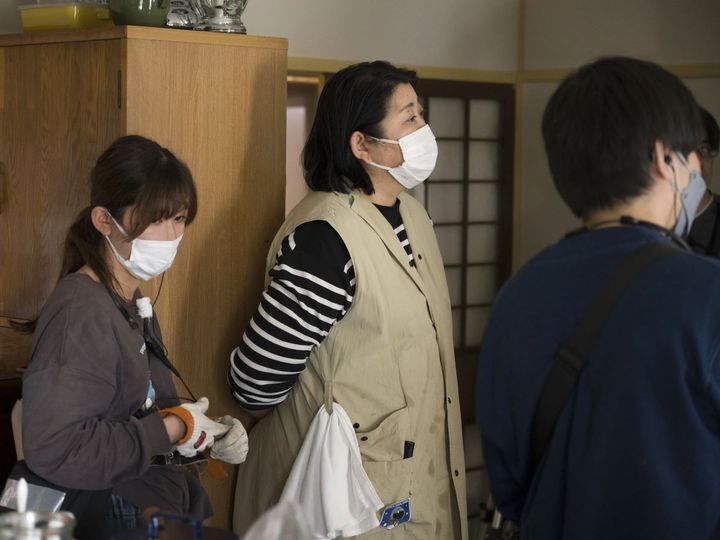 さとこの部屋で撮影に立ち会う飯島さん。