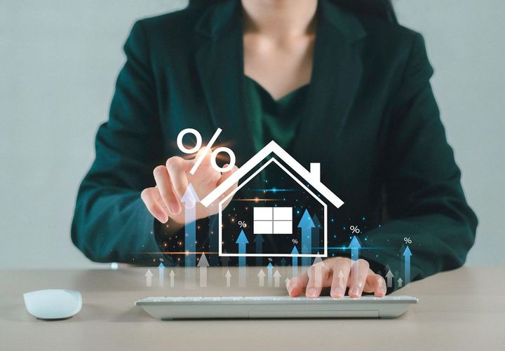 家とパーセンテージアイコンに触れる女性