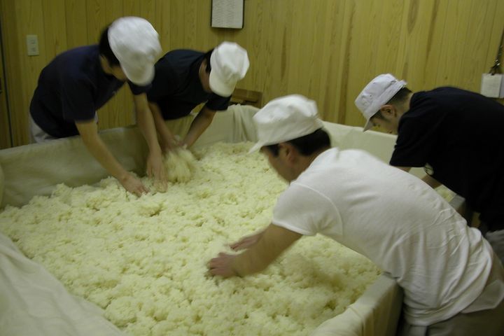 蒸し上がった酒米は手作業で掘り起こし、蔵人によって麹室に運ばれる。江戸中期に建てられた古い木造蔵にもうもうと湯気が立ち込め、幻想的な光景が繰り広げられていた。