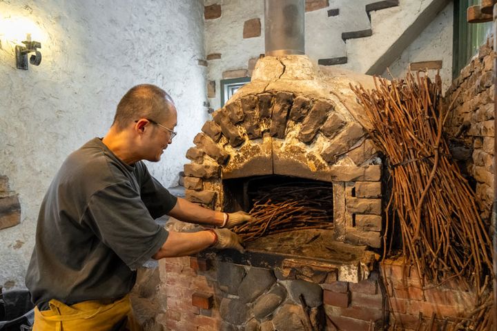 余熱の温度を調整する際に使うのは、山梨のブドウの木の枝。季節や天気によっても熱の上がり方は異なるため、窯の温度調節は職人技