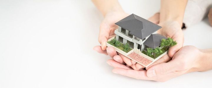 家の模型を持つ2人の手