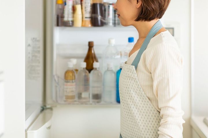 冷蔵庫を見ている主婦