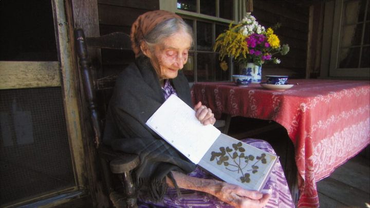 四つ葉のクローバーを見せるターシャ。『ターシャ・テューダー 静かな水の物語』© 2017 映画「ターシャ・テューダー」製作委員会 Photo by Richard W. Brown