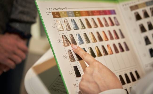 ヘアカラーチャートを見る女性のイメージ