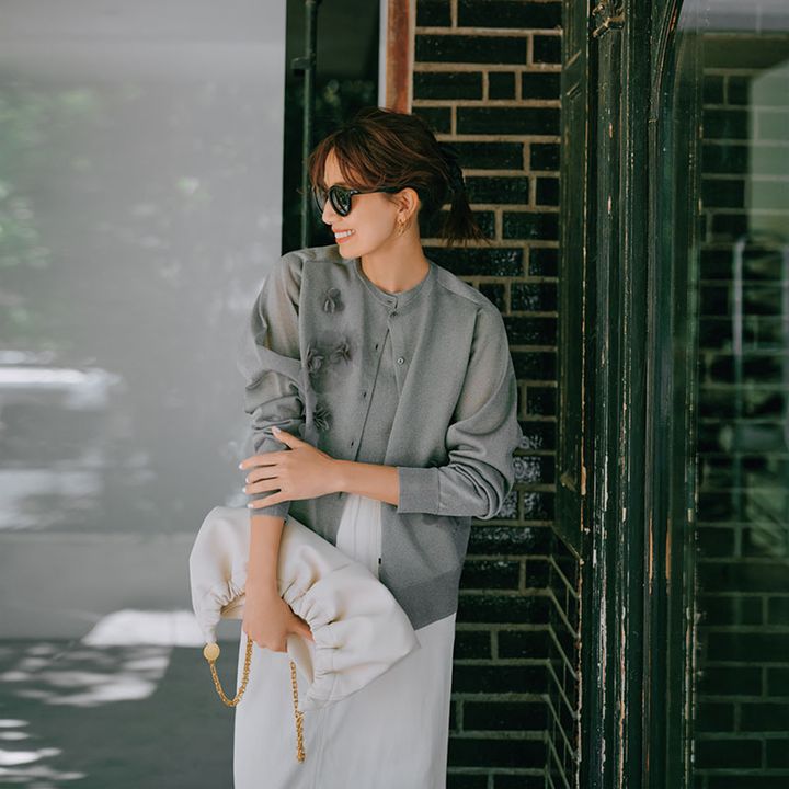 シルバーシアーカーデのアンサンブルに白のボトムス、サングラスのコーデ