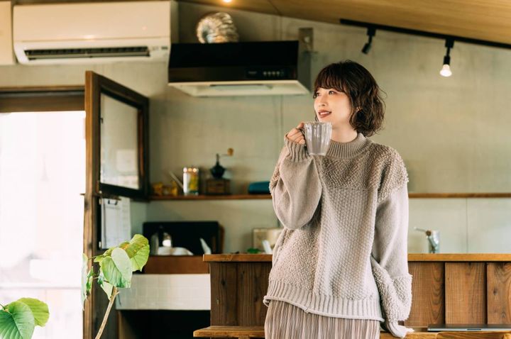 立ってドリンクを飲む女性