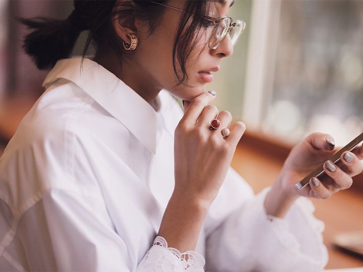 ヴァンクリーフ＆アーペルのペルレのピアスとリングをして携帯を触るママ