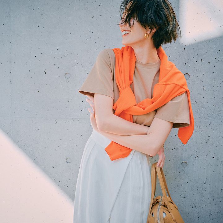 気温27度の日におすすめのベージュT×白パンにオレンジカーデを肩掛けした神山まりあさん