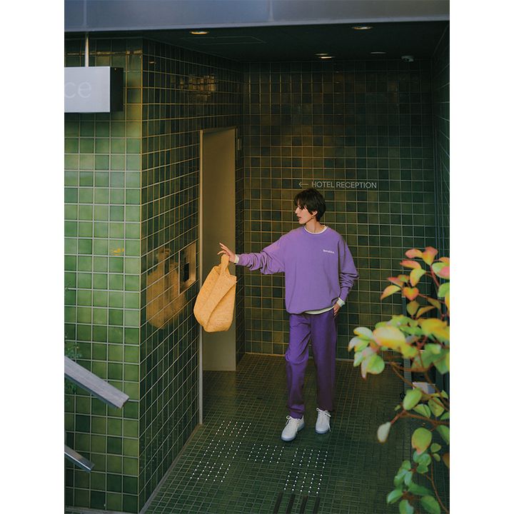 パープルのスウェットの上下にカラーバッグや白スニーカーを合わせたコーデ