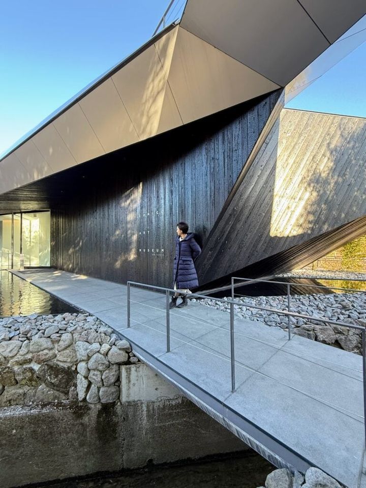 里山の集落をイメージした焼杉の外壁と勾配屋根が特徴