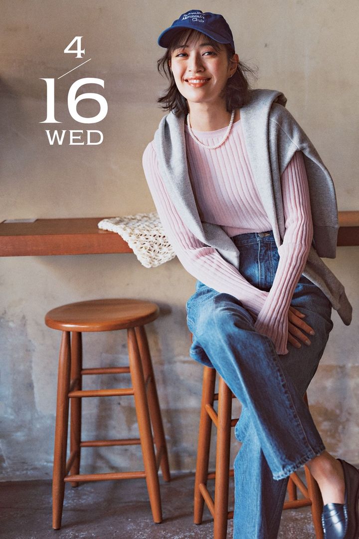 ライラック色のニットとデニムをキャップやローファーでカジュアルに着崩したコーデ