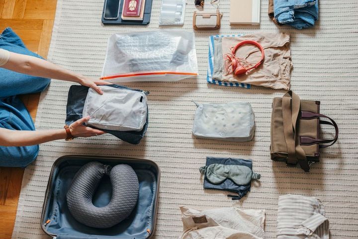 旅行の準備で荷物を詰めようとしている女性