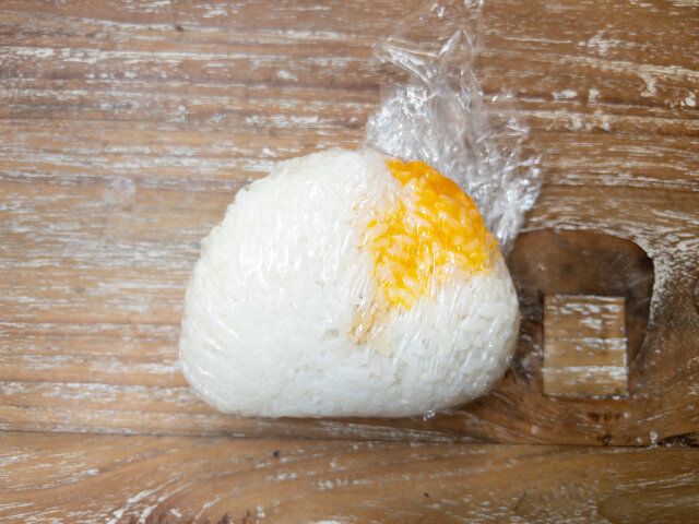 卵黄をふんわりごはんで包むように、ラップでおにぎりを握ります。