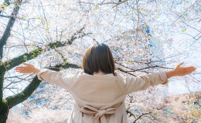 開放感を感じ両手を広げている女性