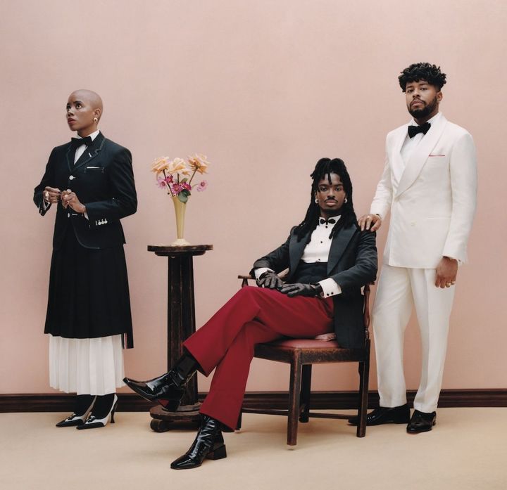 〈写真右 左から〉BBCのTVシリーズ「The Listeners（原題）」で監督兼プロデューサーを務めるジャニクサ・ブラヴォーは、「ダンディズムとは伊達であり、ウィットであり、自分自身に対するある種の余裕と心地よさ」だと語る。モデルのアルトン・メイソンは、赤いパンツが目を引くヴァレンティノのスーツを。アーティストのフェラーリ・シェパードは、ブルネロクチネリの純白のスーツでカクテル仕様にドレスアップ。<br /> 〈Janicza〉ジャケット シャツ スカートすべて参考商品 タイ ¥40,700 シューズ ¥167,200／すべてTHOM BROWNE（トムブラウン 青山） 「マクリカラー」イヤリング YG╳WG╳ダイヤモンド╳スペサルティン ¥7,315,000 リング（左手・人さし指） YG╳WG╳ダイヤモンド╳スペサルティン ¥5,555,000／ともにBUCCELLATI（www.buccellati.com） リング（右手・中指と小指、左手・中指）／すべてDAVID YURMAN（www.davidyurman.com） <br /> 〈Alton〉ジャケット ¥726,000 シャツ¥242,000 パンツ ¥231,000／すべてVALENTINO（ヴァレンティノインフォメーションデスク） グローブ／SEYMOURE GLOVES（seymouregloves.com） シューズ 参考商品／CHRISTIAN LOUBOUTIN（クリスチャン ルブタン ジャパン） <br /> 〈Ferrari〉ジャケット パンツともに参考商品／ともにBRUNELLO CUCINELLI（ブルネロクチネリジャパン） シャツ／ETON（www.etonshirts.com） シューズ 参考商品／CHRISTIAN LOUBOUTIN（クリスチャン ルブタン ジャパン）