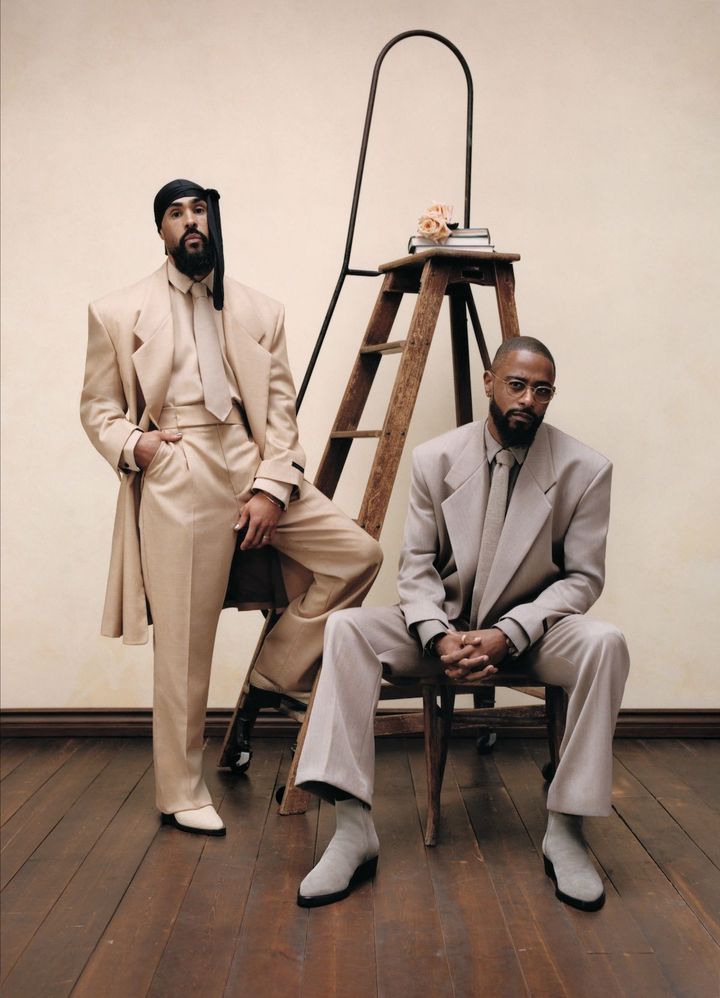 ニュートラルなエレガンス <br /> デザイナーのジェリー・ロレンゾ（左）とリン・ラムジー監督の新作映画『Die, My Love（原題）』に出演した俳優のラキース・スタンフィールド（右）は、ともにフィア オブ ゴッドを纏う。「黒人のスタイルの歴史には、多くの創造性が見られると思います」とロレンゾは言う。「黒人のスタイルとは、ある種の特別な場所に出入りしやすくするための手段なのです。それは必ずしも個として認識されるためではなく、ただ目に留めてもらうために必要なものです」<br /> 〈Jerry〉ジャケット シャツ パンツ タイ シューズ／すべてFEAR OF GOD（fearofgod.com） リング／DAVID YURMAN（www.davidyurman.com） 「タンク」ジュエリー ウォッチ YG╳ダイヤモンド╳オニキス ¥14,784,000（参考価格）／CARTIER（カルティエ カスタマー サービスセンター） <br /> 〈LaKeith〉ジャケット シャツ パンツ タイ シューズ／すべてFEAR OF GOD（fearofgod.com）
