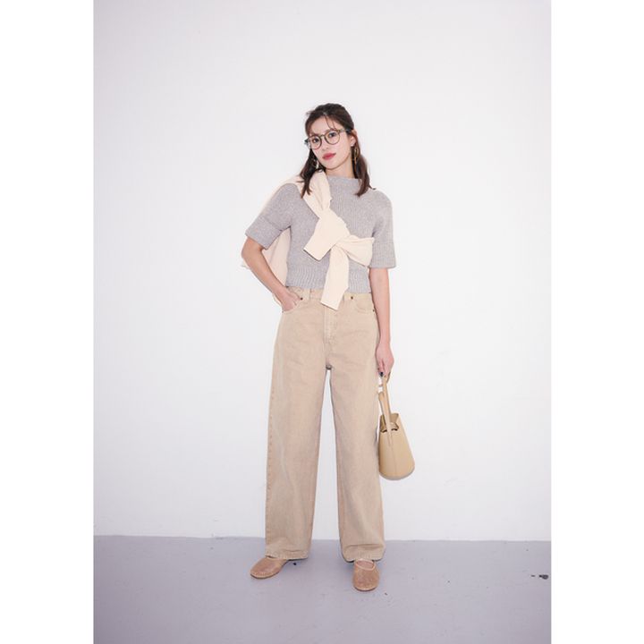 半袖ニットにカーディガンを肩掛けしてベージュのデニムパンツと小物を合わせたコーデ