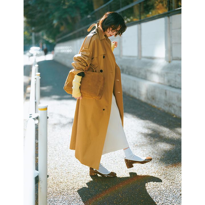 白スカートとトレンチにミュウミュウのスエードバッグとエナメルのストラップ靴を合わせたコーデ
