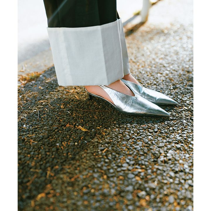 オールブラックのコーデのアクセントになるパンツの折り返しとジルサンダーのシルバーパンプス