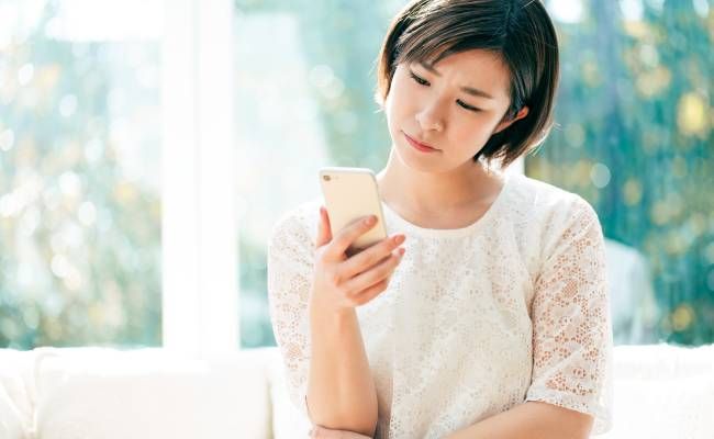 スマホで調べ物をする女性のイメージ