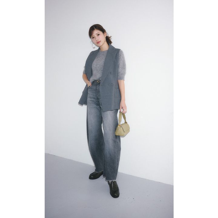 グレーの半袖ニットとジレにヤヌークのカーブシルエットのグレーデニムを合わせたコーデ