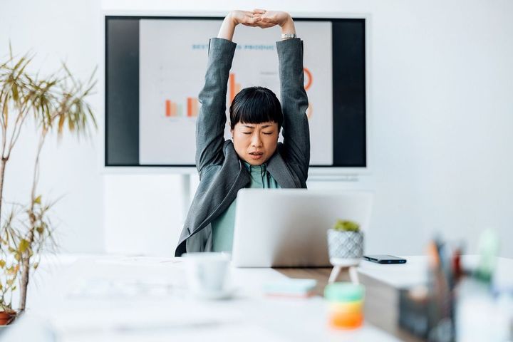 両手を上げて伸びをする女性