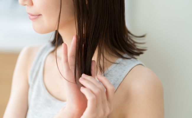 髪にオイルを塗っているイメージ