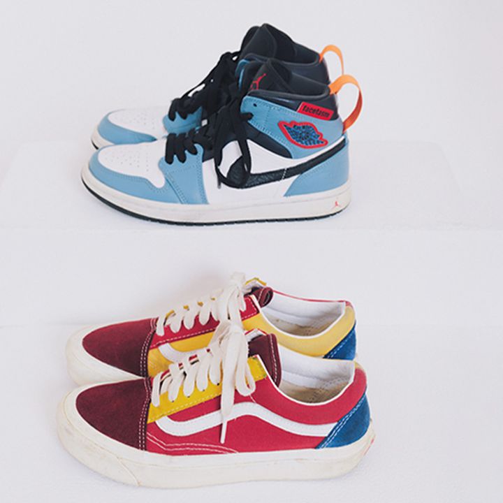 水色の白のコンビにオレンジや赤のアクセントが入ったナイキのスニーカーと赤や黄色にスエード素材のヴァーガンディ色が入ったローカットスニーカー