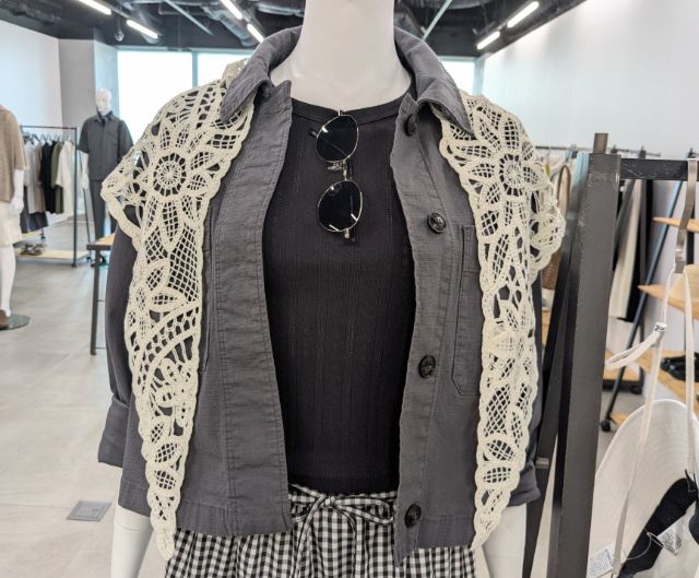 クロシェスカーフを肩がけしている